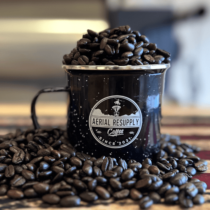 Cavalry Bold Dark Roast Blend whole bean coffee in an Aerial Resupply Coffee Logo Campfire Mug on an american flag