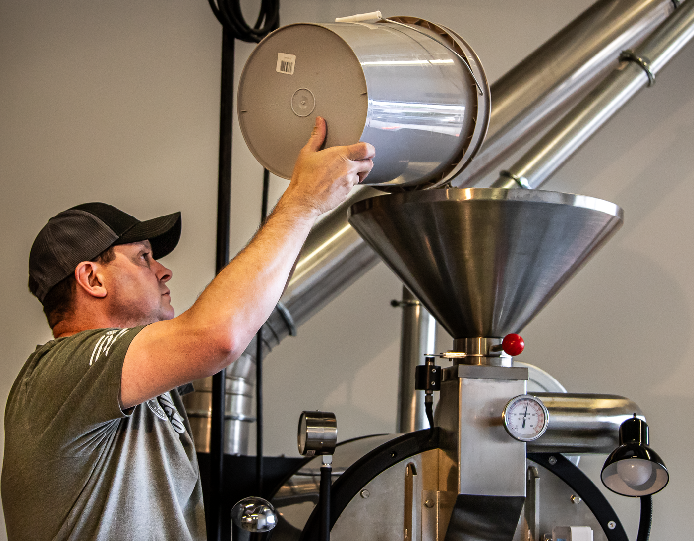 Mike Klemmer loading green coffee into the roaster at the Aerial Resupply Coffee roastery in Charlottesville