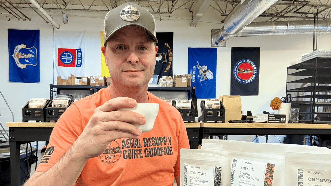 a man sitting at a table wtih a cup of coffee