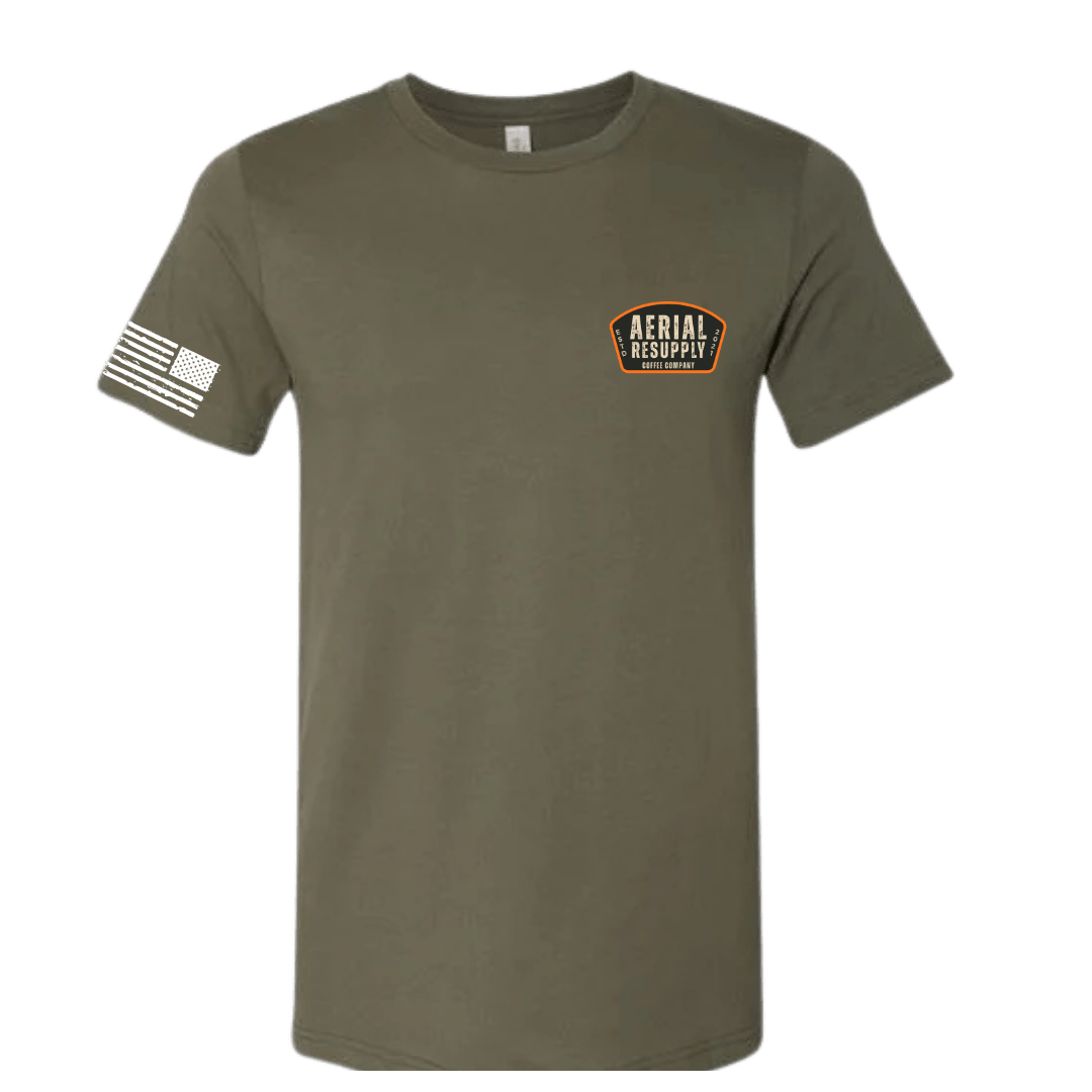 Olive green t-shirt with a logo on the chest and a flag on the sleeve against a white background