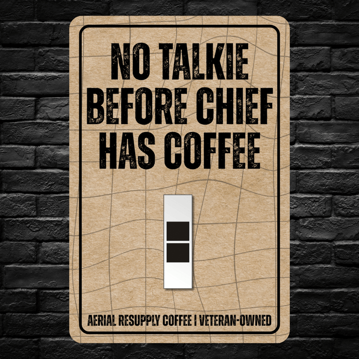 Light switch cover with 'No Talkie Before Chief Has Coffee' text on a brick wall background