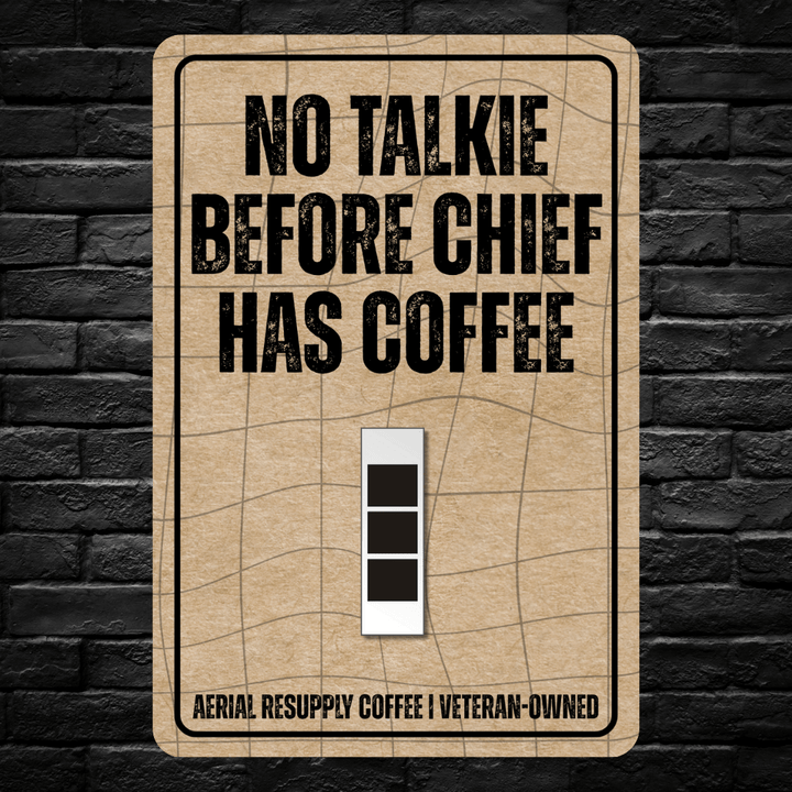 Light switch cover with 'No Talkie Before Chief Has Coffee' text on a brick wall background