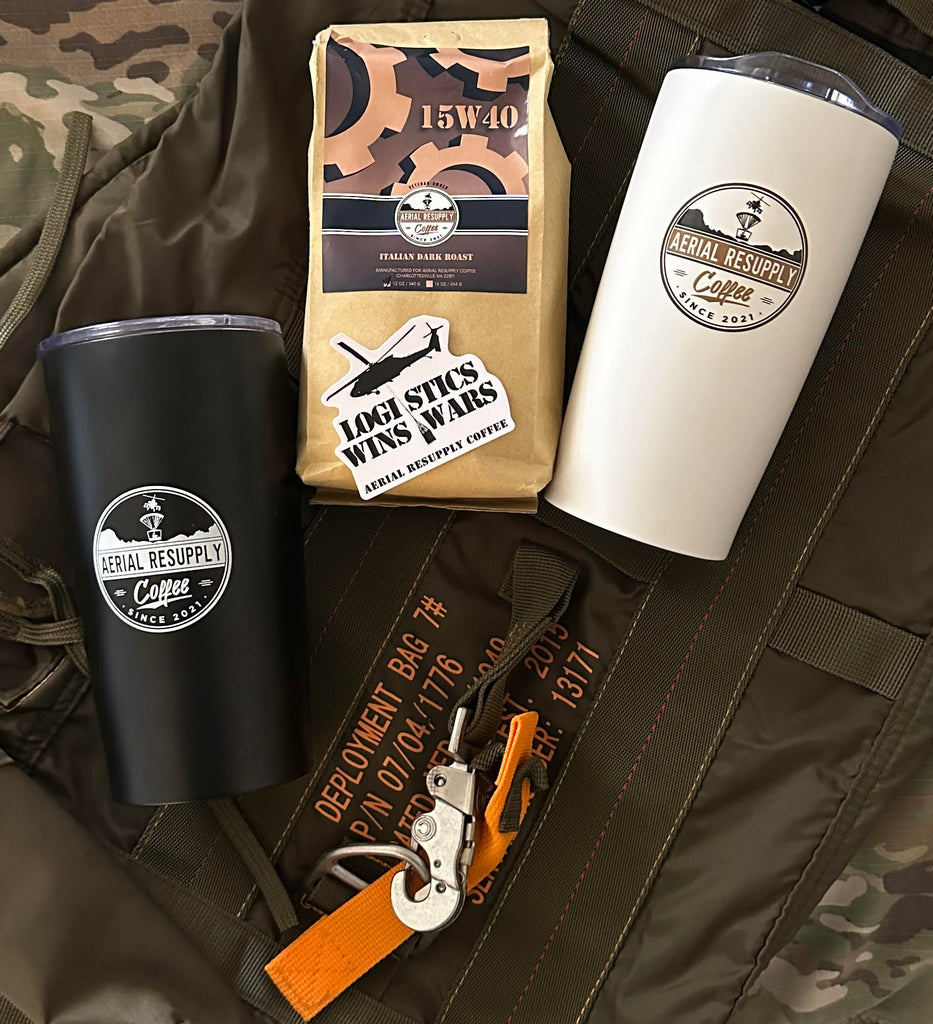 2 tumblers and a bag of 15W40 Coffee from Aerial Resupply Coffee laying on a deployment parachute bag
