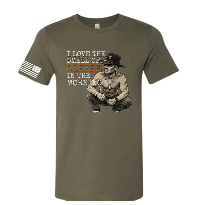 Olive green t-shirt with graphic of a man and text 'I love the smell of coffee in the morning' on a white background