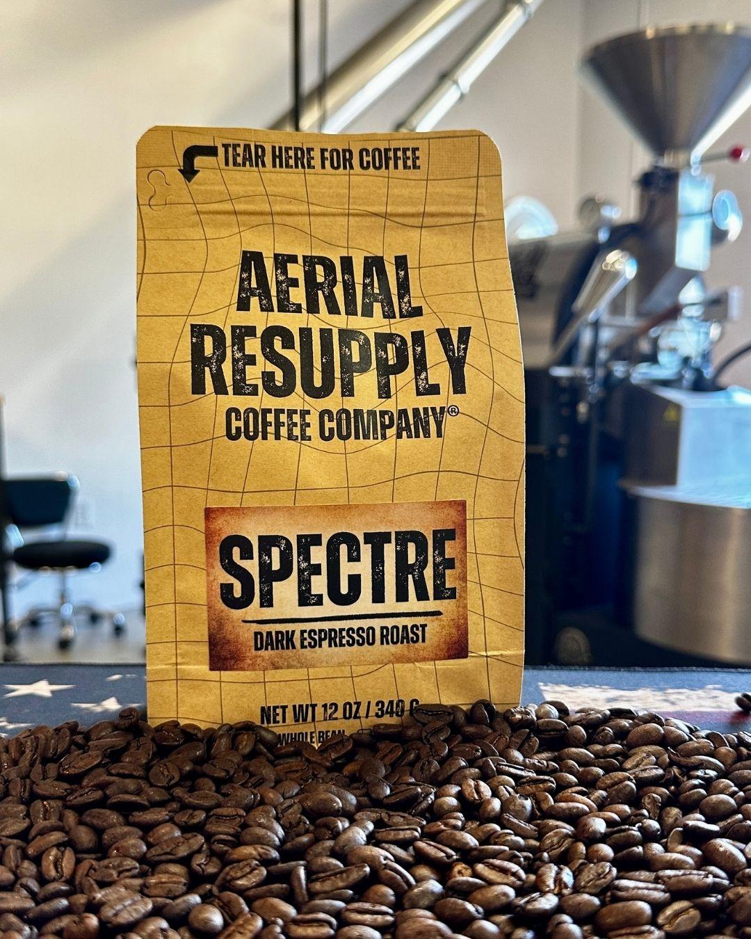 Aerial Resupply Coffee Company Spectre dark espresso roast coffee bag on a bed of coffee beans.