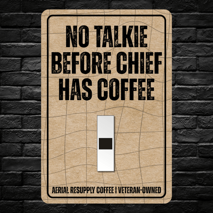 Light switch cover with 'No Talkie Before Chief Has Coffee' text on a brick wall background